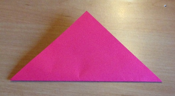 Das Origamipapier wird fuer die Papiertulpe einmal in der Mitte zu einem Dreieck gefaltet